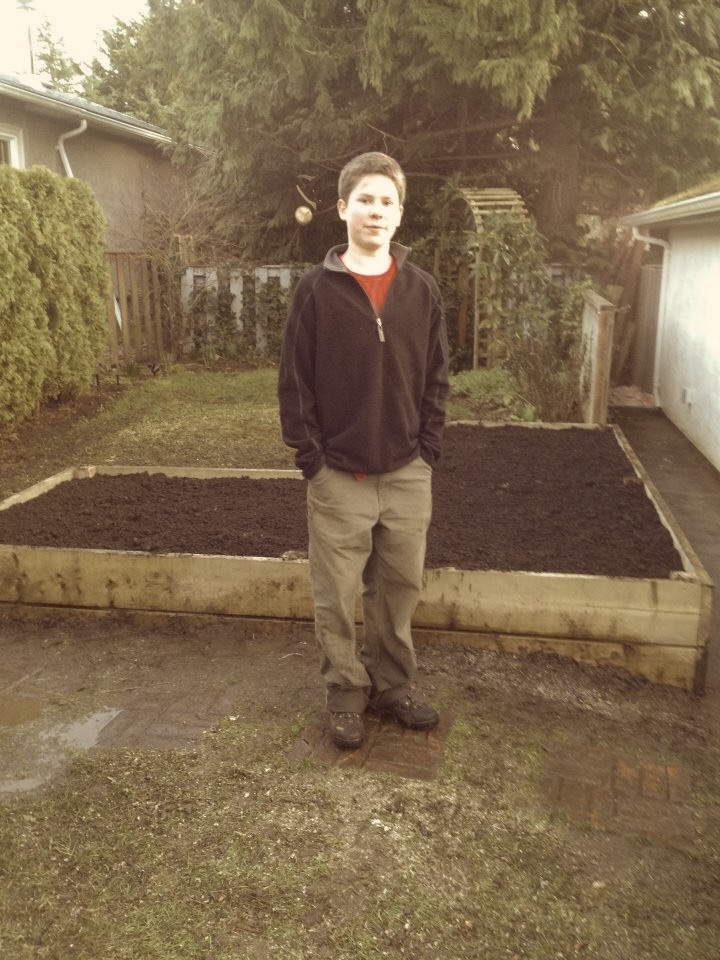 Me standing in front of my garden bed after sowing the first seeds